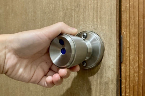 鍵がついた室内用ドアノブを持っている手元の写真