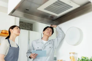 換気扇の故障を点検する作業員の写真
