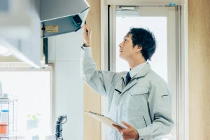 換気扇を点検する作業員の写真