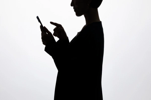 スマホを操作する女性の影