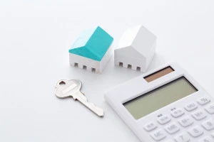 家の模型とカギと電卓の画像