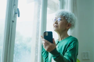 雨の中不安なシニア女性の写真