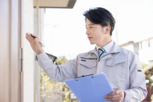 玄関ドアの点検をする男性の写真