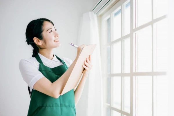 窓を眺めながらメモを取っている女性