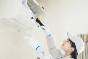 エアコン清掃をする女性業者スタッフの写真