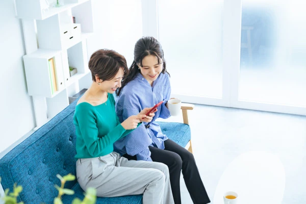 スマホの画面を見る女性達