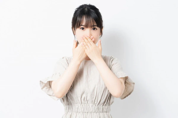 口に手を当てている女性の写真