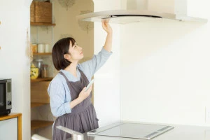 換気扇をチェックする女性の写真