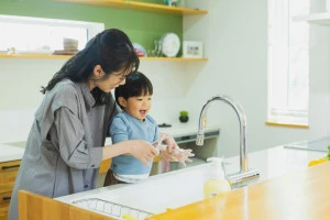 キッチンで手を洗う子供とお母さんの写真