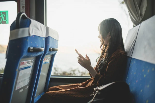 一人でバスに座る女性の写真