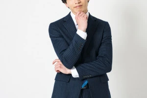 悩んでいるスーツ姿の男性の写真