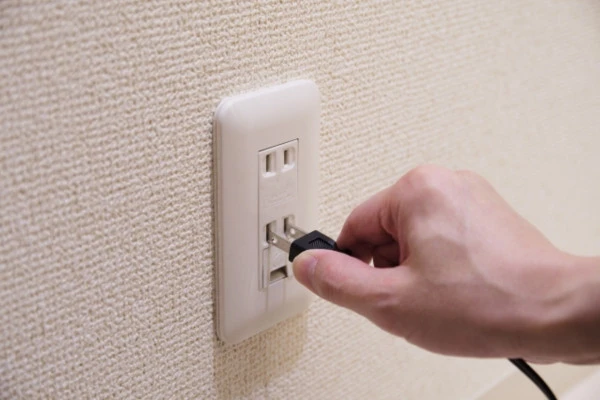 ウォシュレットが水漏れした時に電源プラグを抜く様子