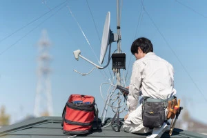 アンテナ工事をしている男性の写真