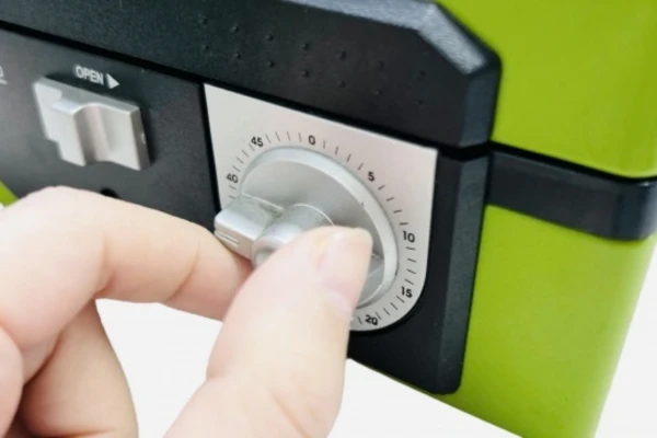 ダイヤル式金庫のツマミを持って回している様子