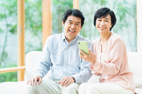 スマホを持つミドル世代の男女の写真
