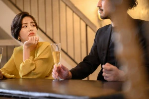 不満そうに相手の男性を見つめる女性の写真