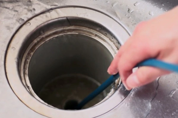 排水溝の臭いを取るため掃除する様子