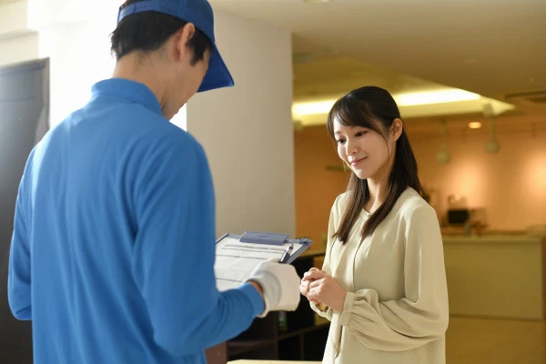 会話をする作業員の男性と若い女性の写真