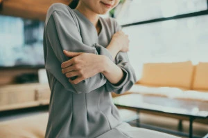 部屋の中で寒がる女性の写真