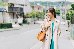 トレンチコートを着て街ブラする女性の写真