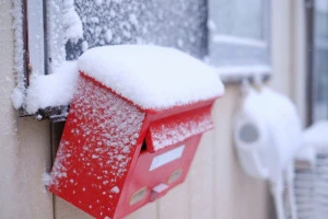 吹雪で雪まみれの郵便受けの写真