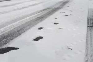 雪に残ったタイヤと足の跡の写真