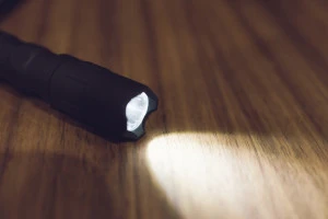 机の上を照らす懐中電灯の写真