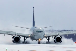 雪煙を巻き上げて着陸する航空機の写真