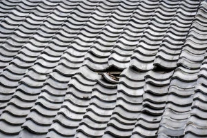 瓦の剥がれた屋根の写真