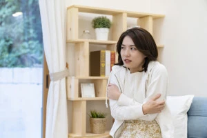 部屋の中で寒がる女性の写真