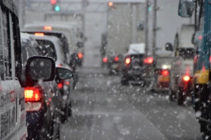 雪の降る道路と車の写真