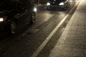 雪の降る道路と車の写真
