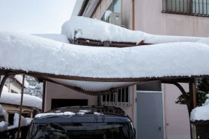 雪の重みで壊れたカーポートの屋根の写真