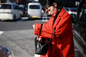 駐車場で車の鍵をさがす女性の写真