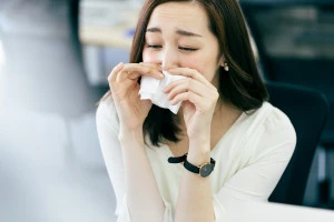 鼻をかんでいる女性の写真