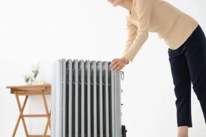 オイルヒーターを設置する女性の写真