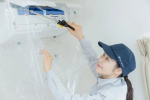 エアコンクリーニングを行う女性作業員の写真