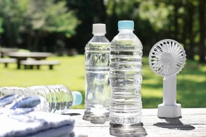 水の入ったペットボトルとハンディファンの写真