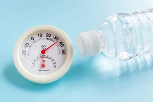 30℃越えの温度計と水の入ったペットボトルの写真