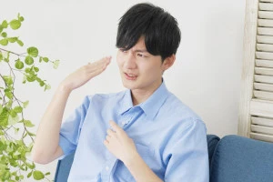 自宅で手うちわをする男性の写真