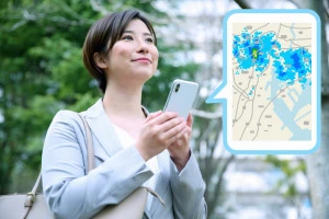 スマホで雨雲レーダーをチェックする女性のイメージ画像