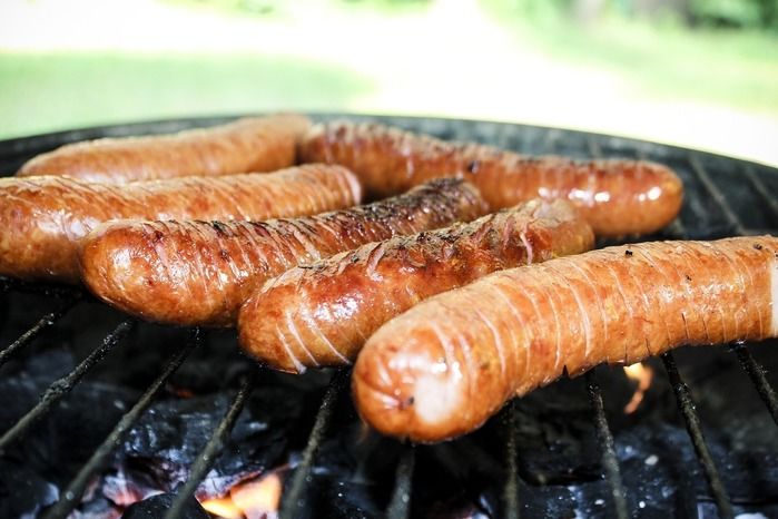 バーベキューでソーセージを焼いている写真