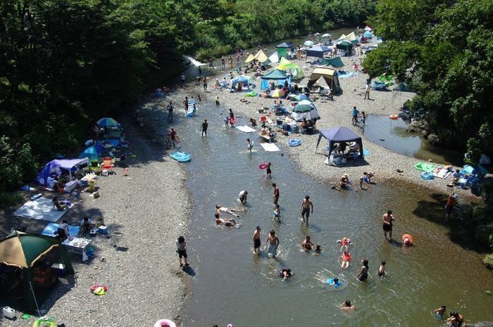 川沿いにテントを貼って、川で遊んでいる人たち
