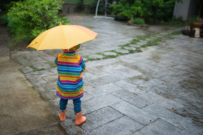 カッパを着て傘を持っている子供の写真