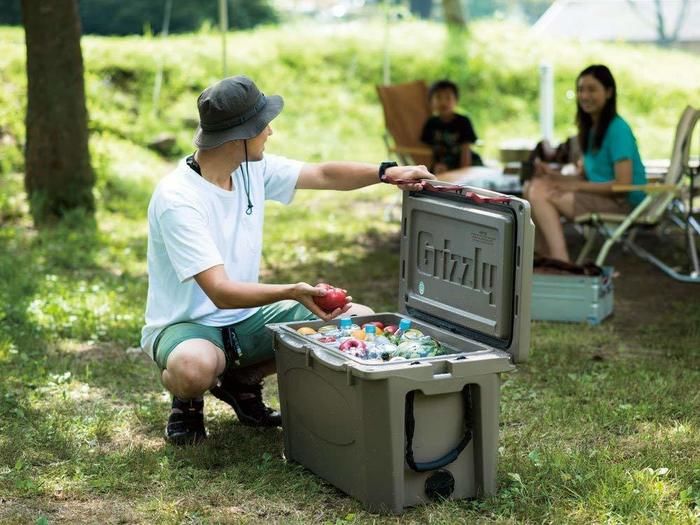 クーラーボックスから食材を取り出す男性