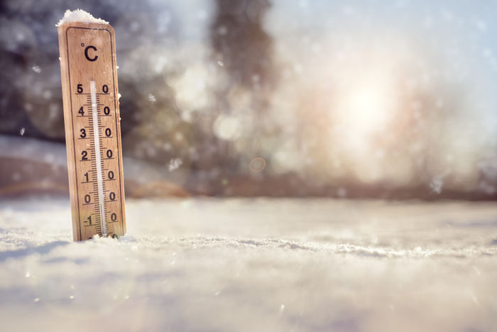 雪の地面に刺さっている温度計