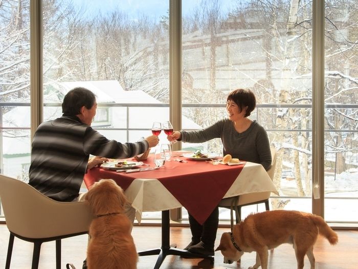 八ヶ岳わんわんパラダイスのコテージでペットと一緒に宿泊している夫婦の写真