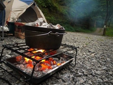 キャンプで炭を焚いて鍋を温めている様子の写真