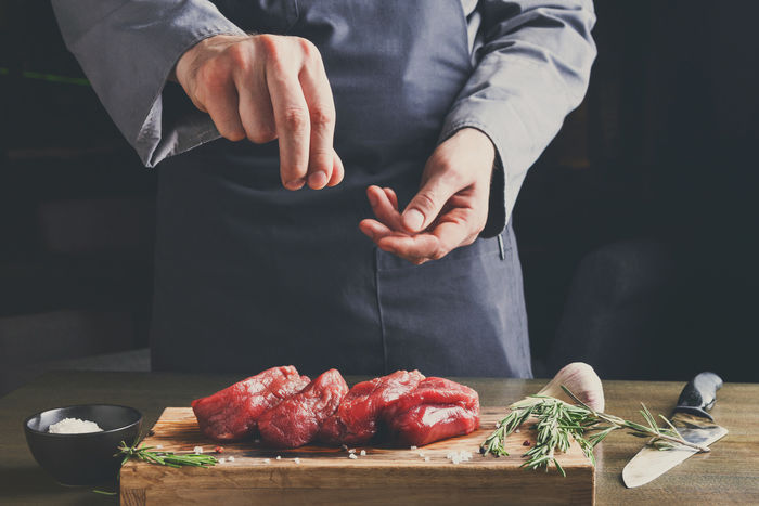 肉に塩をまぶして下味をつけている様子