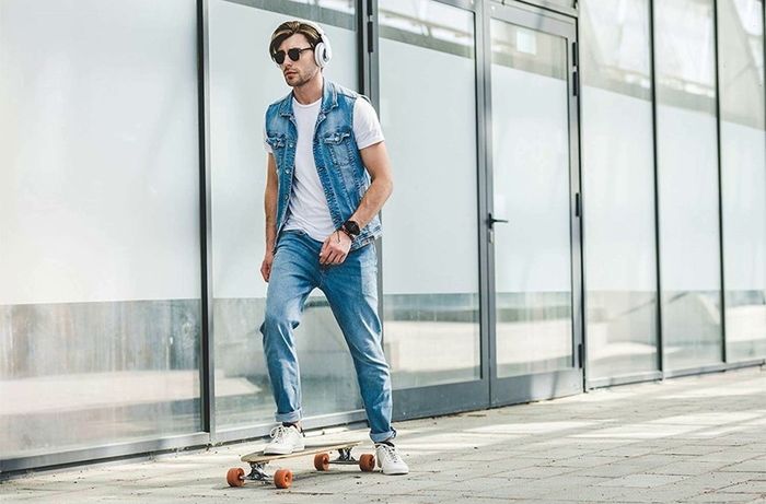 スマートウォッチをつけてスケボーを滑っている男性の写真